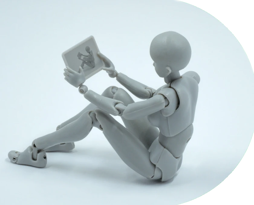 Boneco robótico sentado segurando um tablet com uma imagem dele mesmo.